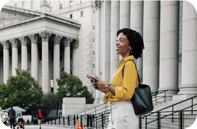 A woman with a cellphone in front of a government building